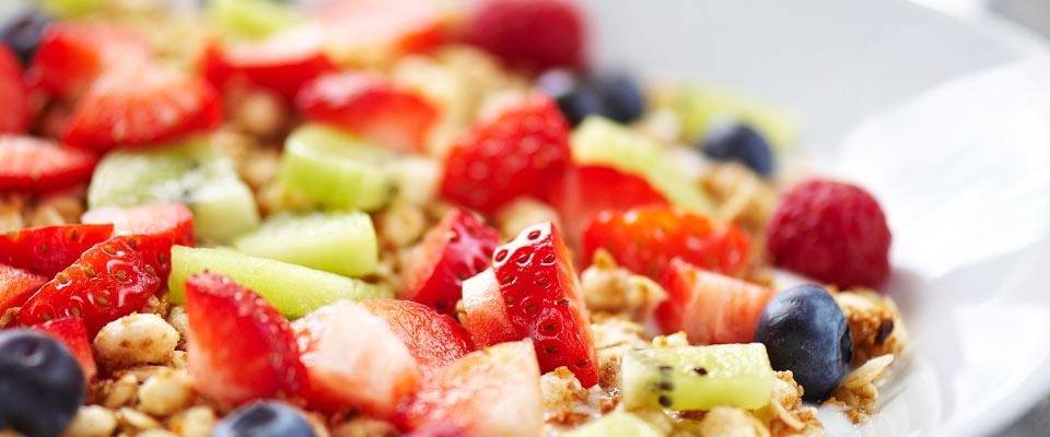 Breakfast plate with fresh fruit on muesli and yogurt