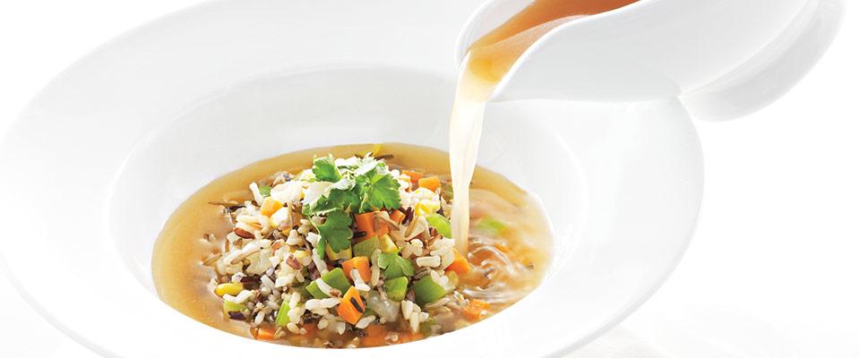 Vegetable soup being poured into a bowl