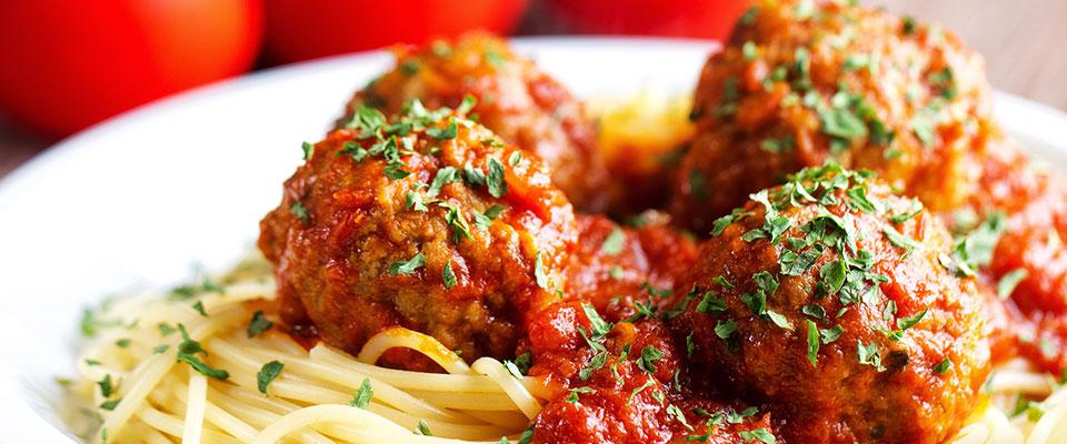 Plate of spaghetti and meatballs with garnish