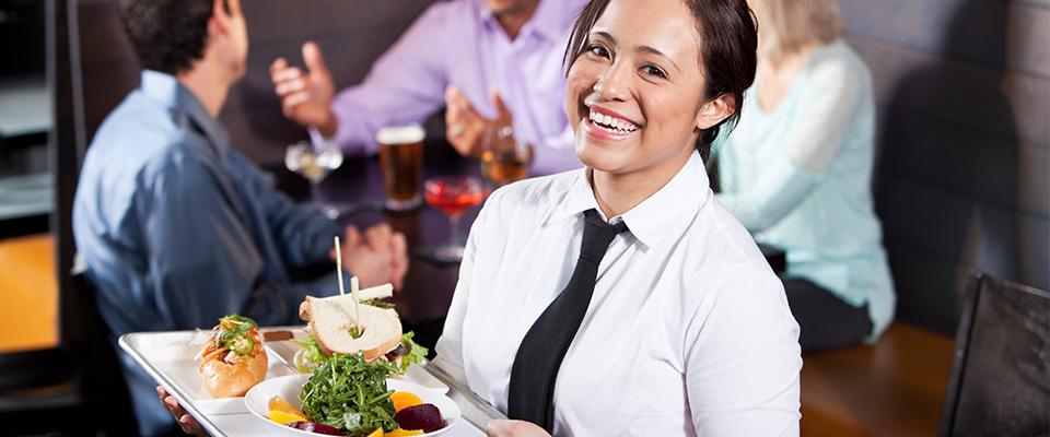 Female server carrying tray with food