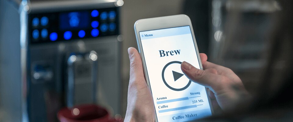 Person using smart phone to brew coffee