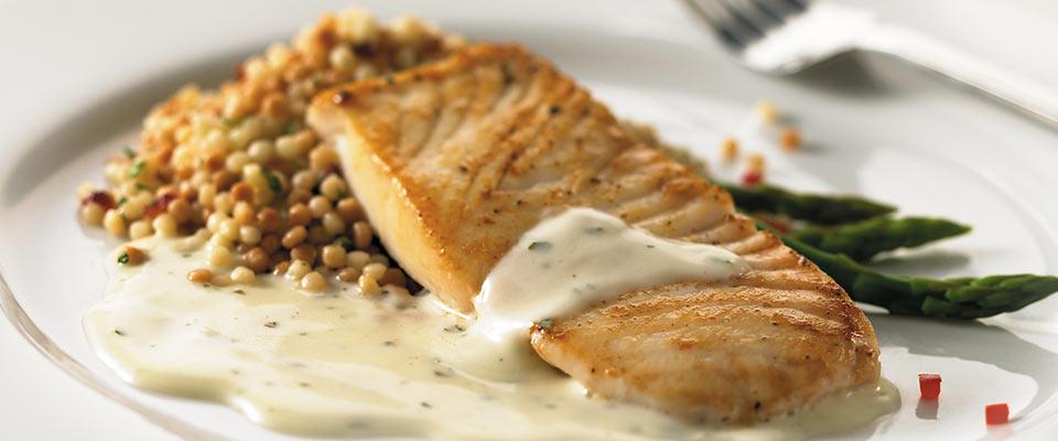 Plate of salmon with basil and creamy alfredo sauce