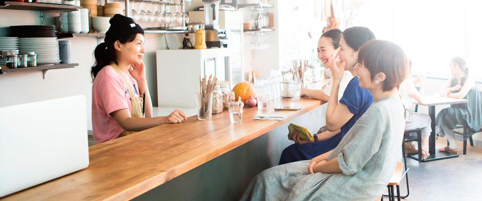 Women sitting at a cafe counter with iced lattes