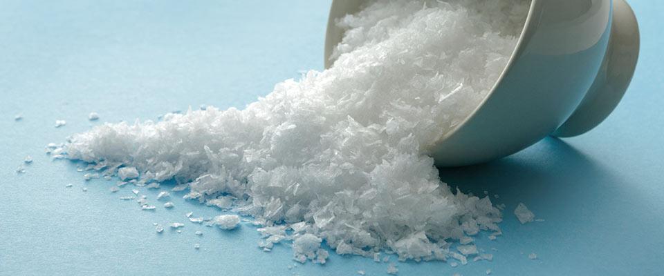 Bowl of salt poured onto blue surface