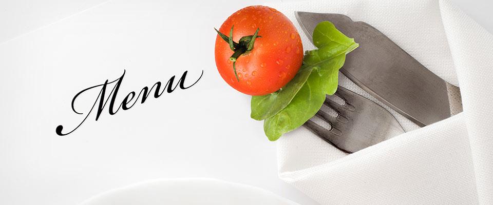 Table setting and menu with tomato and greens