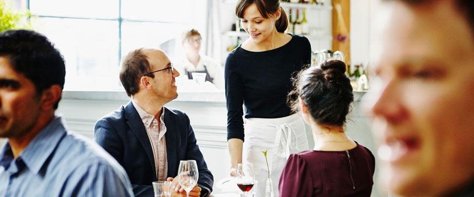 Waitress offering drinking suggestion to customers