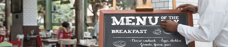 chef updating an outdoor menu board