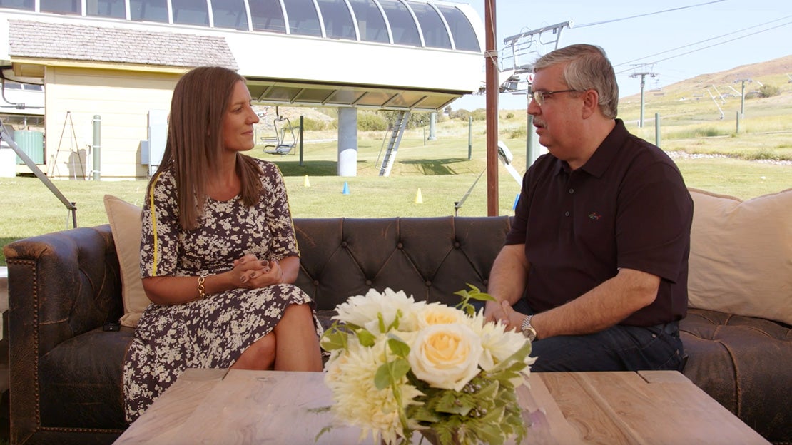 Perry and Fleur sit side by side talking at event