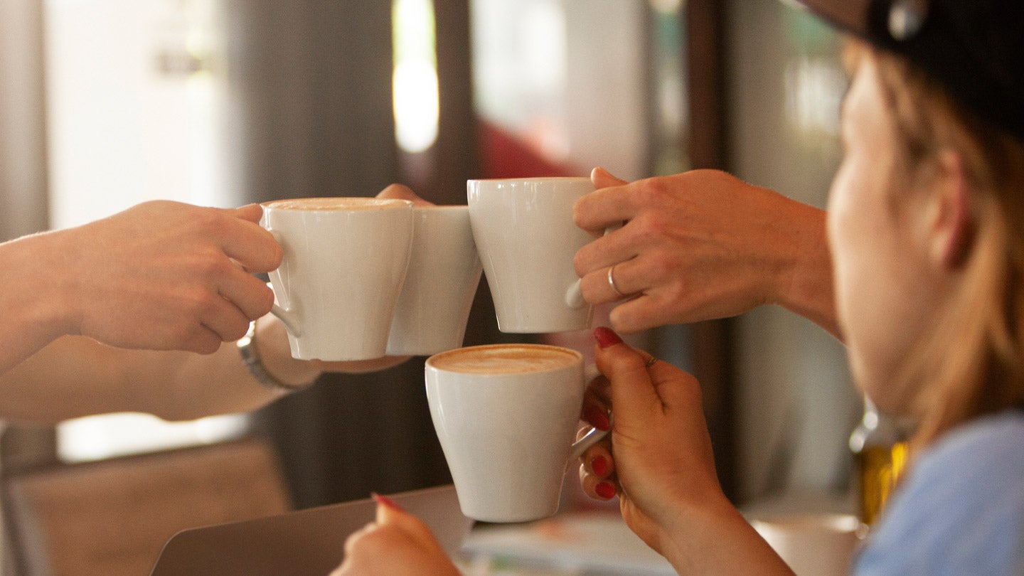 Coffee mugs being raised