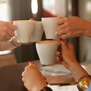 Toasting at a table with coffee cups