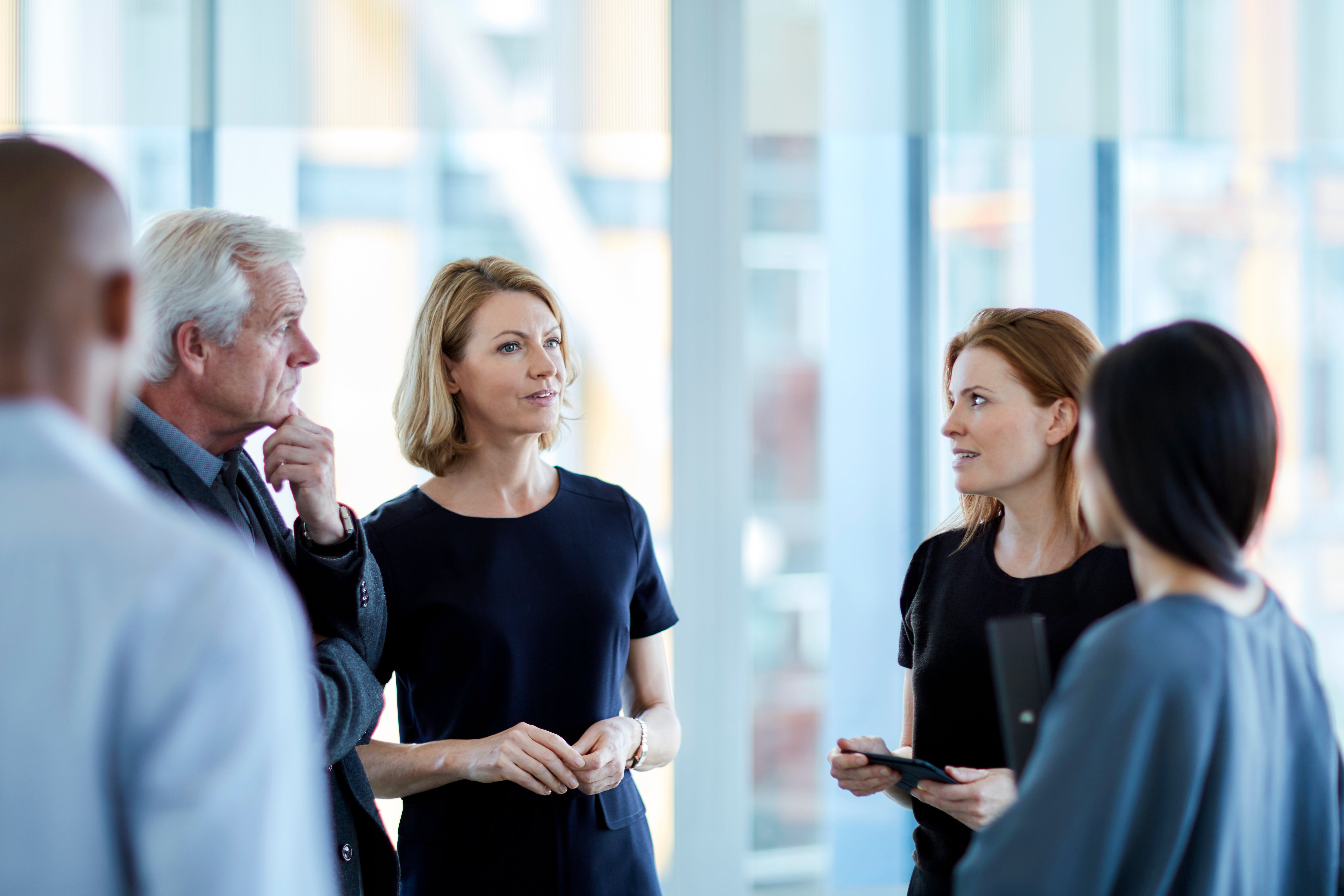 Leaders in a circle with a female in focus speaking