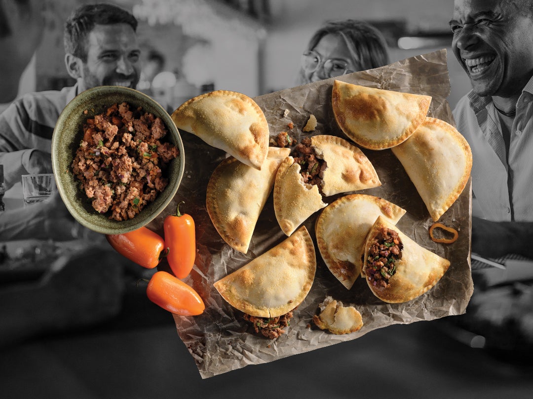 A plate of Sweet Earth Awesome Empanadas made with Sweet Earth Awesome Grounds with three persons smiling in the background