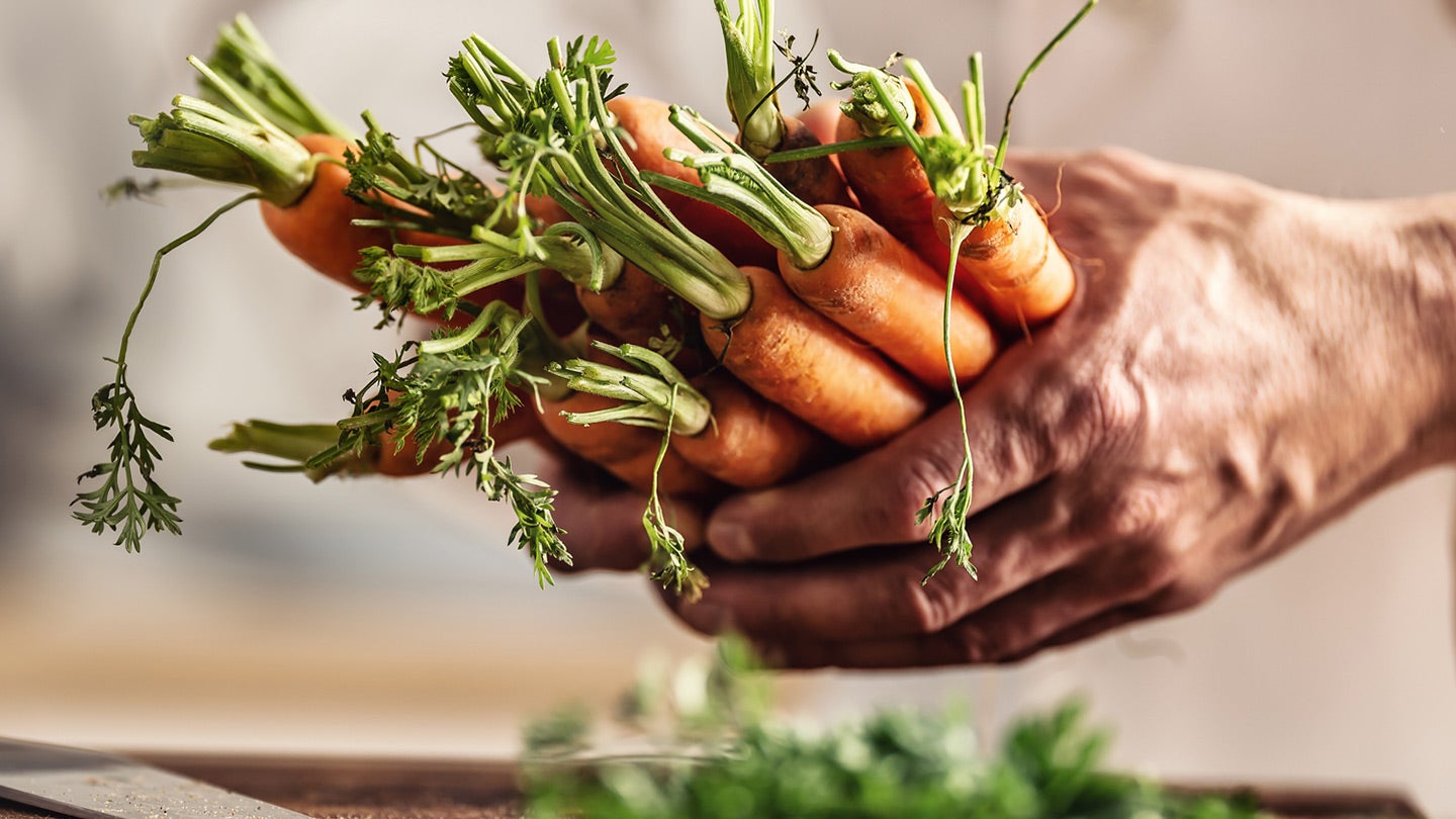 Man holding carrots in his hands
