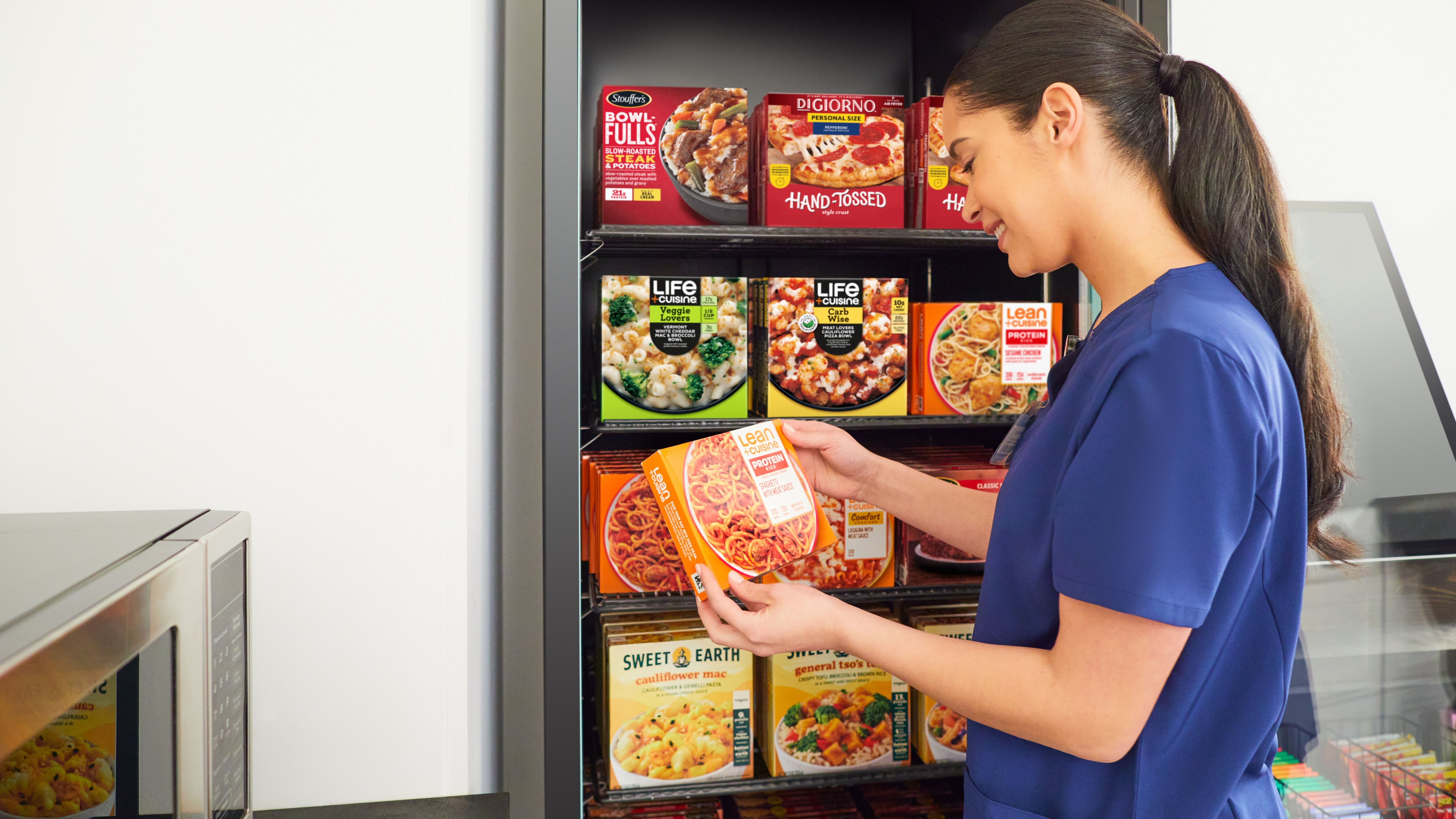 woman looking at Lean Cuisine product from refrigerator