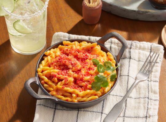 hot macaroni and cheese in cast iron skillet on towel on table