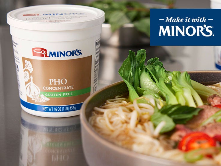 Minor's Pho tub behind plate of ramen and vegetables