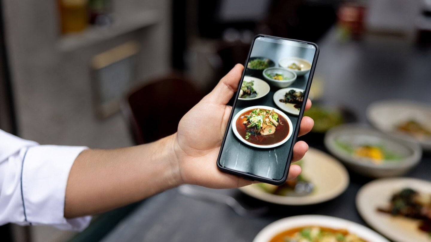 Sustainability person holding cell phone with image of food