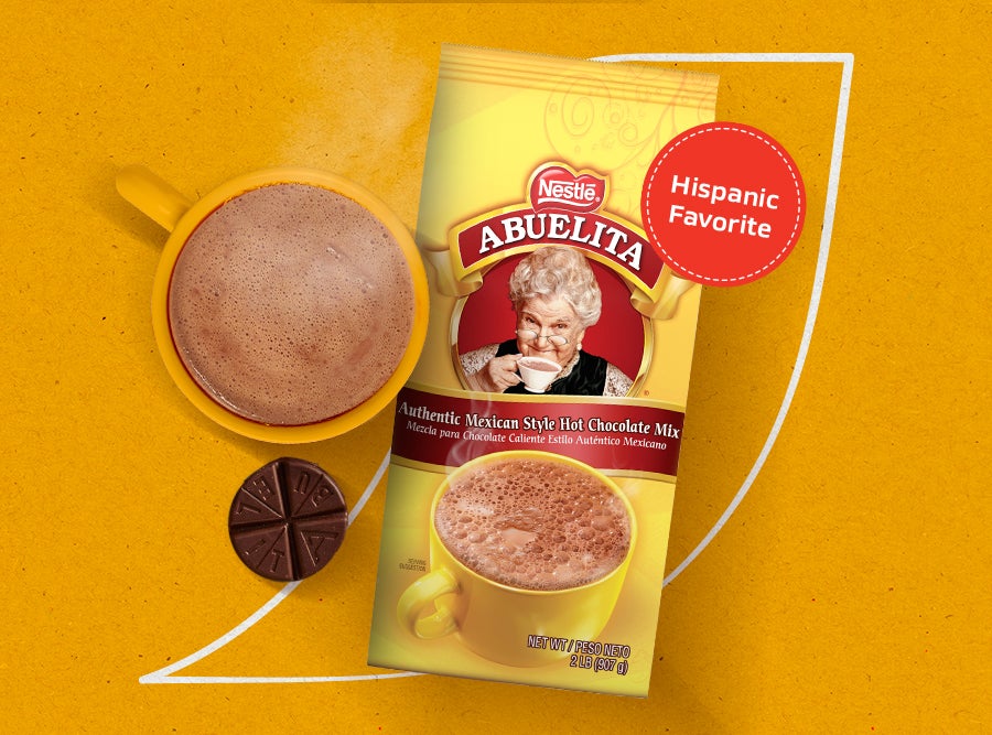 Nestlé Abuelita Authentic Mexican Style Hot Chocolate mix packet and a prepared mug of hot chocolate with a chocolate tablet