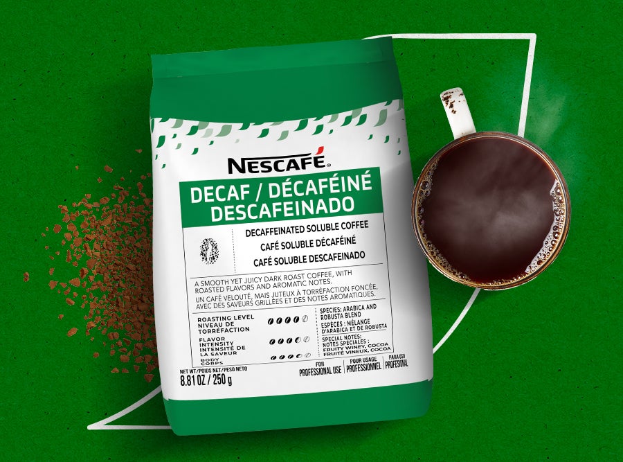 Nescafé Decaf instant coffee pouch with a mug of steaming decaf coffee. Serve the rich aroma and smooth flavor of Nescafé