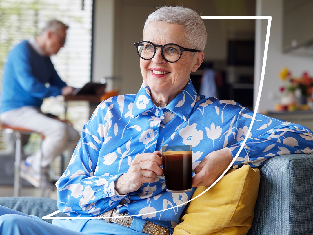 A senior woman enjoying a warm mug of Nescafé Taster’s Choice.