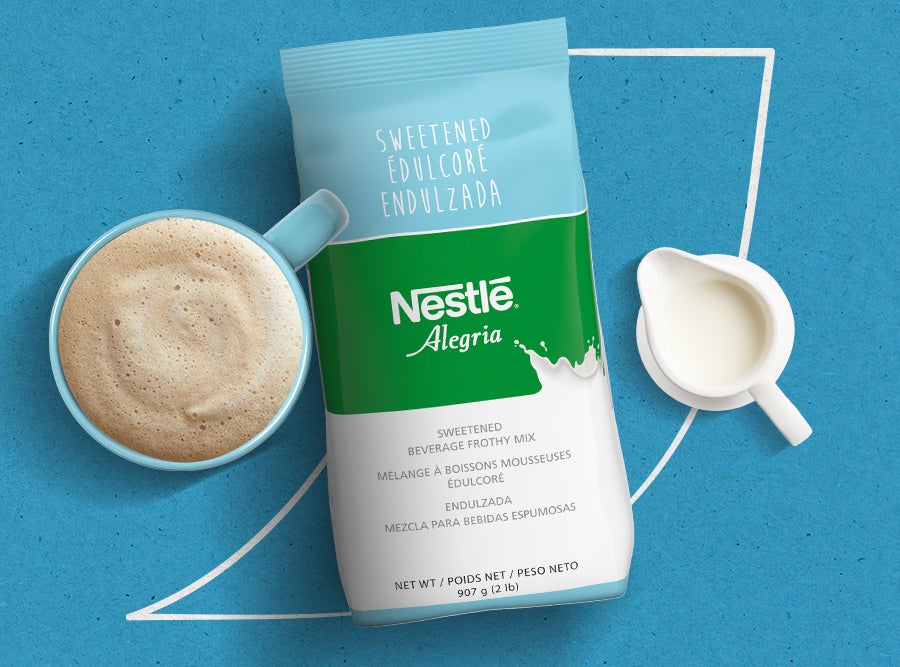 Nestlé Alegria sweetened frothy beverage mix packet, a prepared mug of the drink, and a small pitcher of milk.