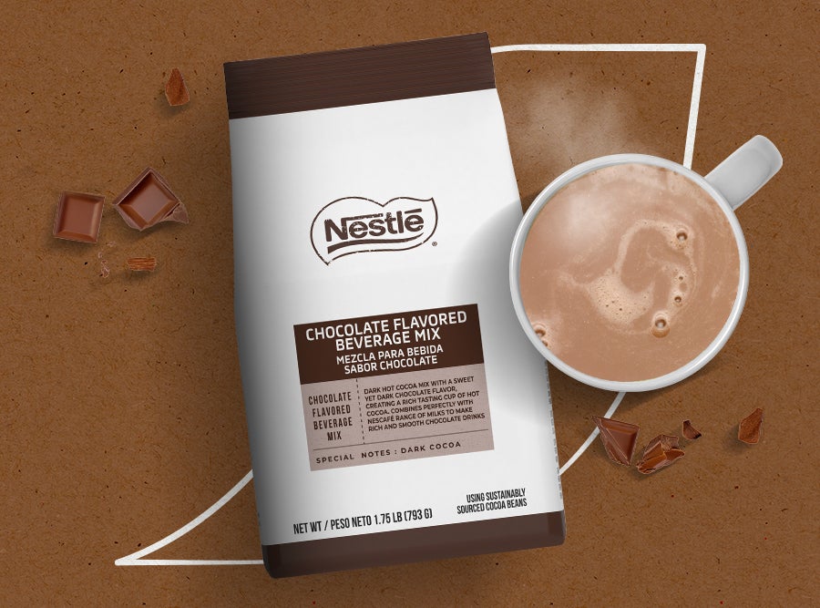 Nestlé Chocolate Flavored Beverage Mix  packet and a mug of steaming hot  chocolate beside chocolate pieces.