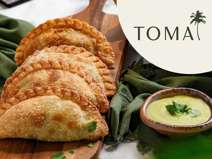Toma empanadas on board with dipping sauce