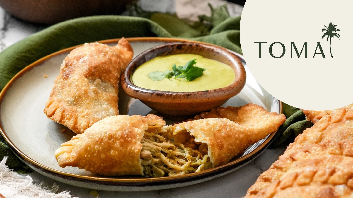 Tooma empanadas open on plate with sauce