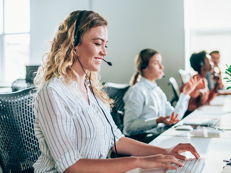 woman at call center with headset typing