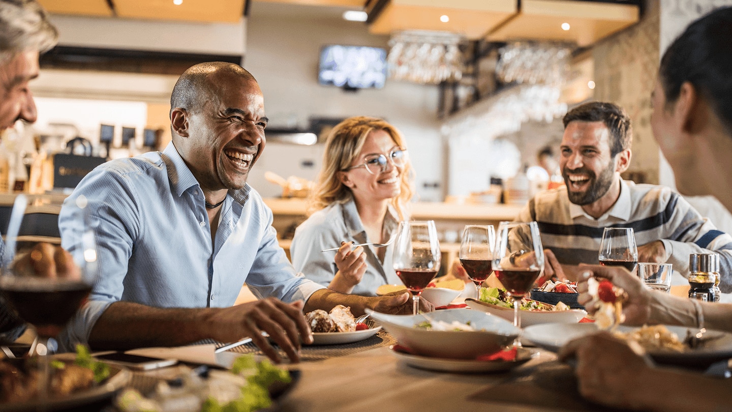 October trend report holiday foodservice people sitting around table sharing food