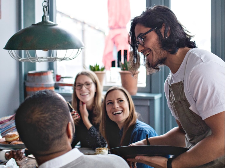 server taking order at table with guests