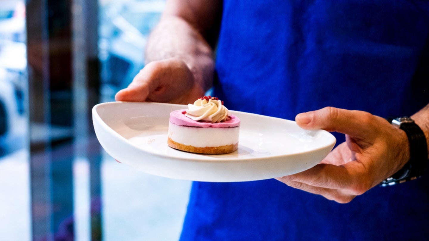 Customer holding a mini cheesecake dessert