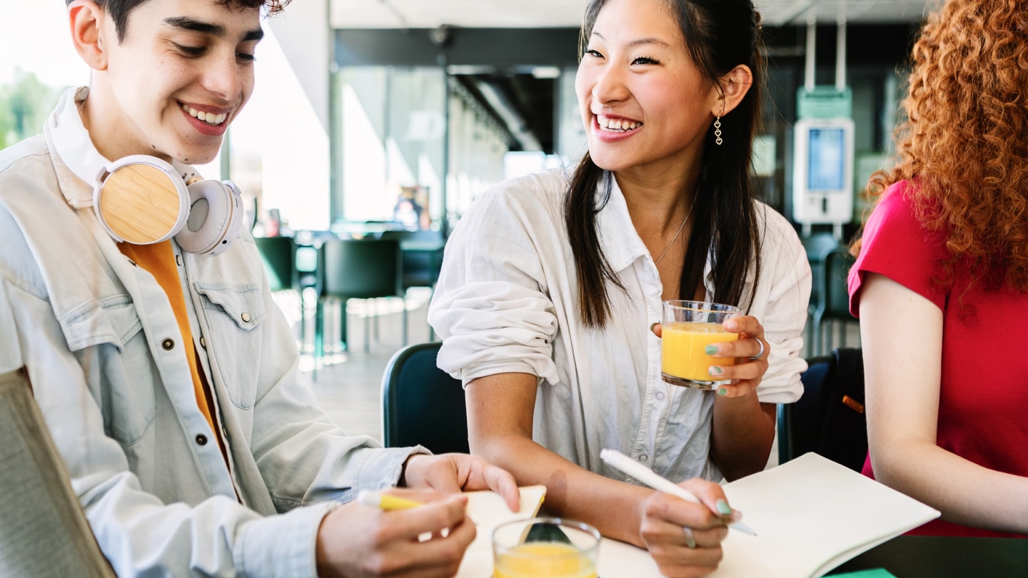 college students drinking juice and doing school work