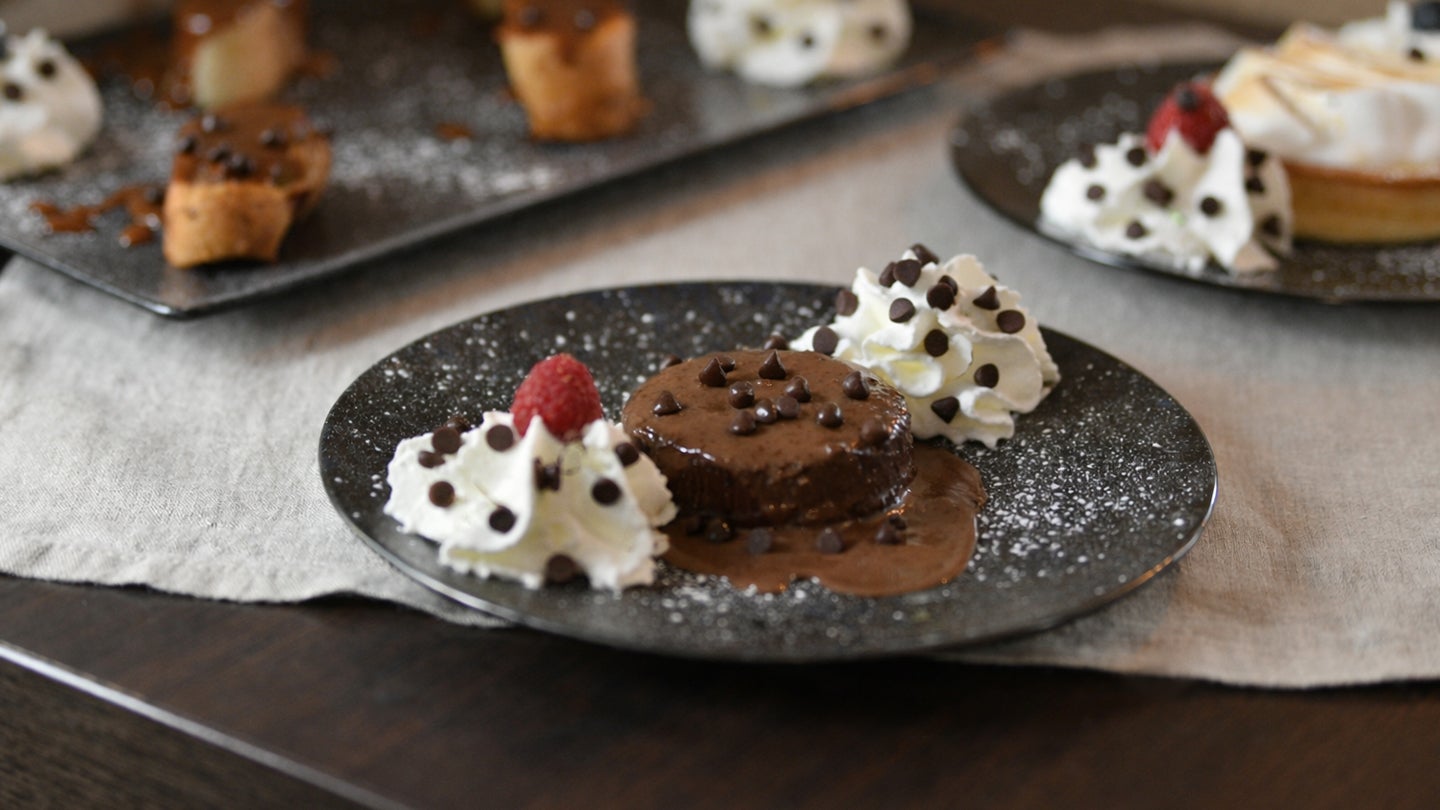 Chocolate mini dessert plated with whipped cream and mini morsels