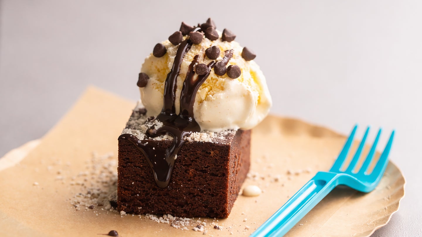 Mini brownie dessert on a plate with a scoop of ice cream topped with mini morsels