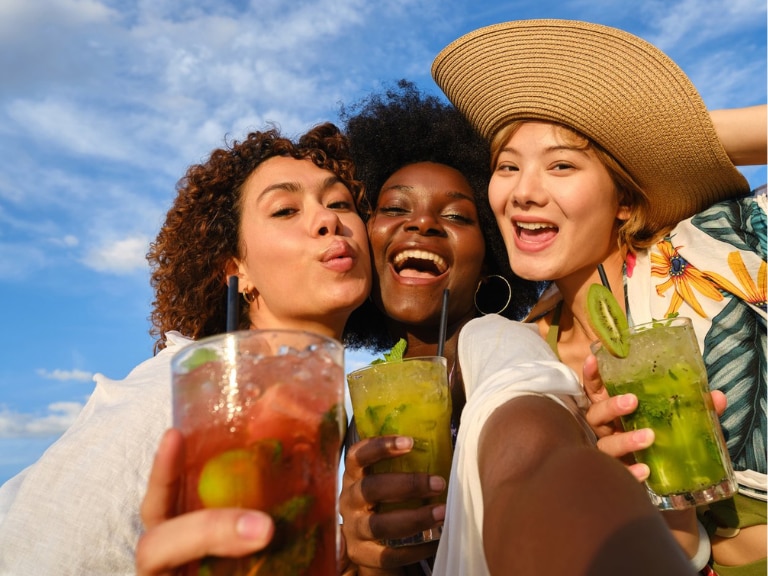 three ladies with drinks in hands smiling