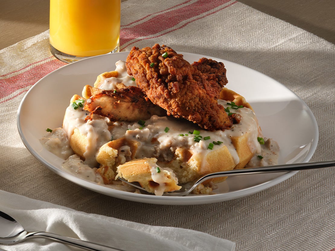A plate of chicken on a waffle with gravy