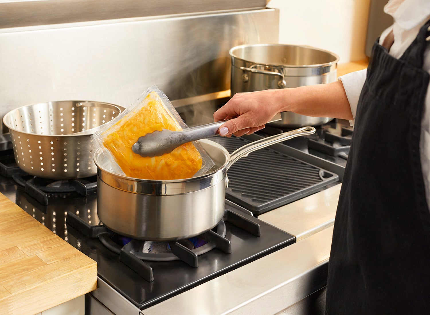 Chef placing macaroni and cheese pouch in water