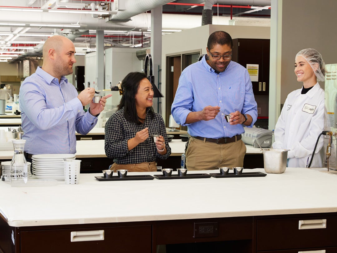 people taste testing products in test kitchen