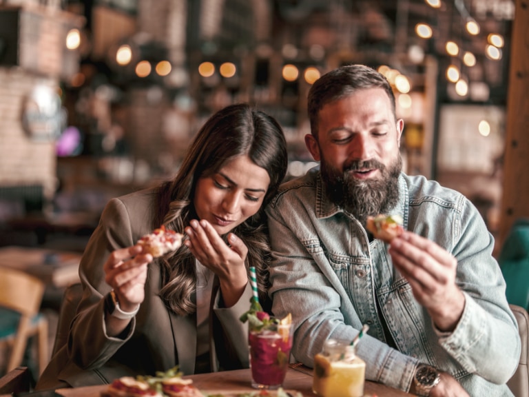 man and woman eating dinner at restaurant