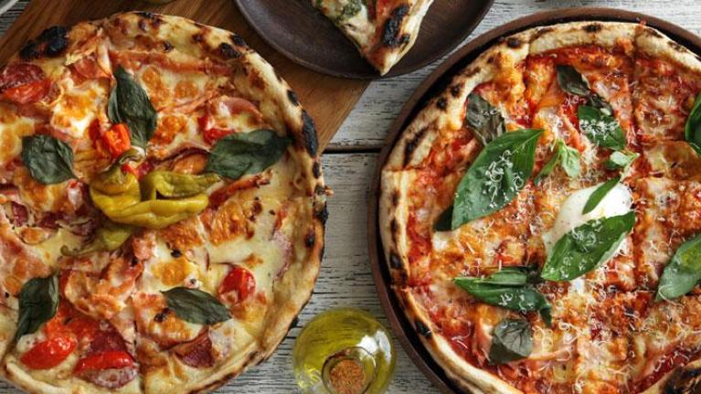 Overhead photo of two pizzas on a table