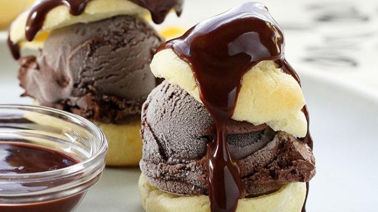 Plate of profiteroles with side of chocolate sauce
