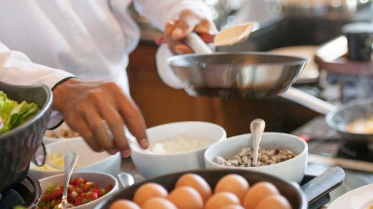 Chef preparing dish at an action station