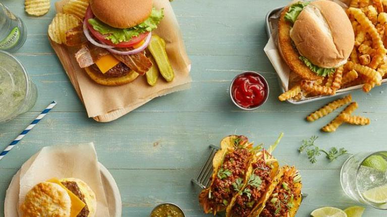 Vegan burger and tacos with drinks photographed overhead