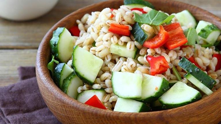 Bowl of pearl barley salad with vegetables