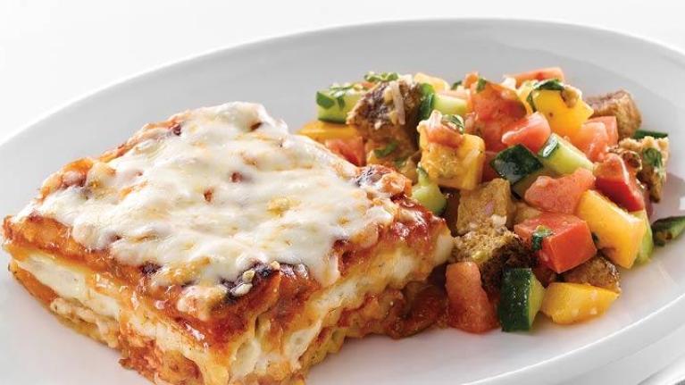 Plate of whole grain lasagna with meat sauce and grilled panzanella salad
