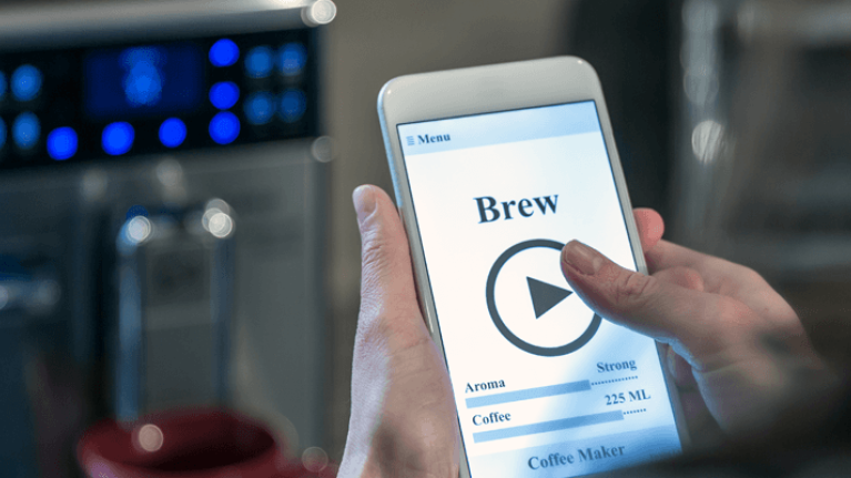 Person using smart phone to brew coffee