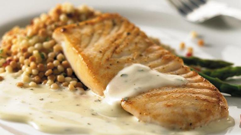 Plate of salmon with basil and creamy alfredo sauce