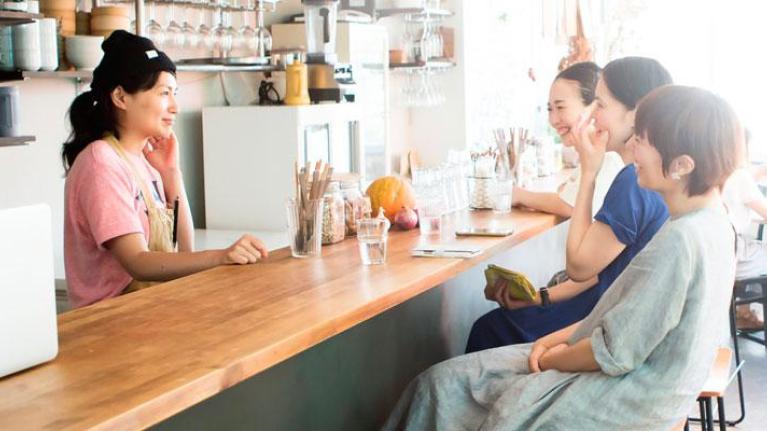 Women sitting at a cafe counter with iced lattes