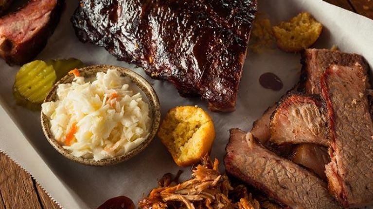 Barbecue smoked brisket and ribs platter in rustic setting